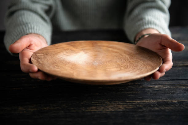 Woman hands holding empty wooden plate