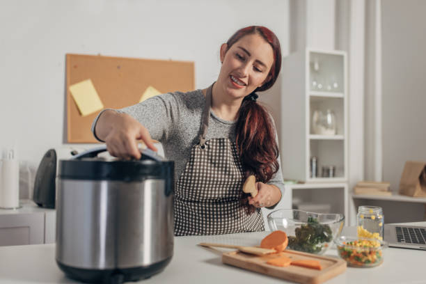 istock Hispanic woman using slow cooker while preparing food in the kitchen 1818464556