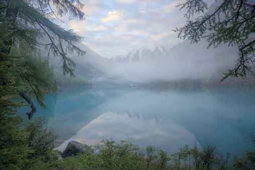 Beautiful mountain landscape with fog. Mountain lake in the fog. A photo with a shallow depth of field. Soft focus.