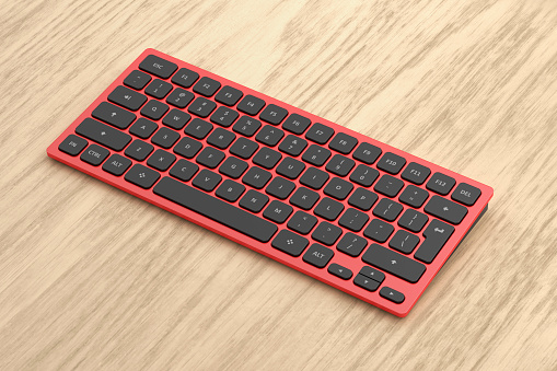 Red computer keyboard on wooden desk