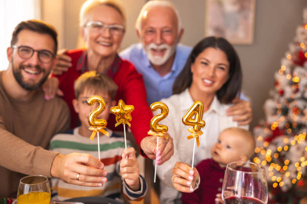 istock Multi-generation family holding balloons shaped as numbers 2024 while having Christmas dinner 1818489285