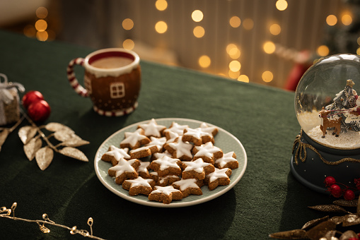 Cookies and warm drink on Christmas decorated table.