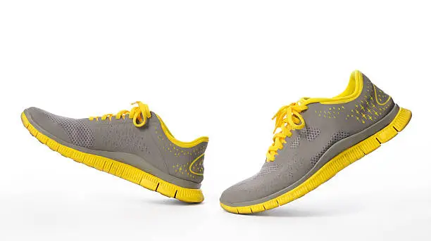 Close-up of walking yellow sneaker isolated on white background with clipping path.