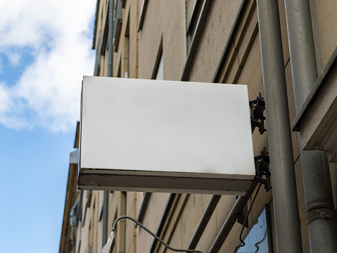 Empty sign on a facade of a business inside the building. Template for testing a logo or a sign next to a wall. Blank mockup to advertise a brand. Signboard of a cafe a restaurant or an office.