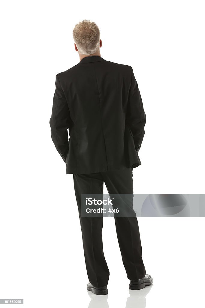 Vista posteriore di un uomo d'affari in piedi - Foto stock royalty-free di Abbigliamento elegante