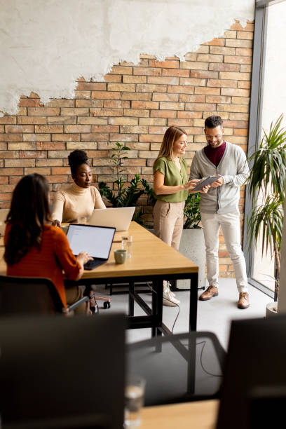 istock Young multiethnic startup team working by the brick wall in the industrial style office 1818502535