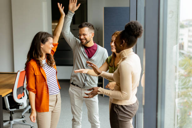 istock Young multiethnic startup team hold hands together in the modern office 1818503064