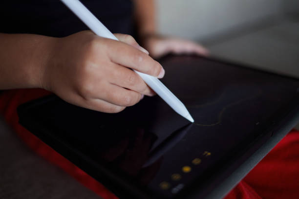 istock A child's hand draws on a tablet using a stylus. Close-up. 1818504162