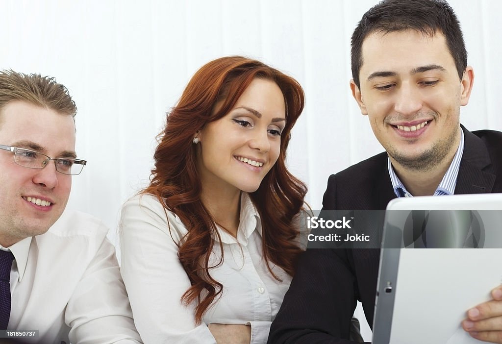 Colleghi che lavorano su un computer portatile. - Foto stock royalty-free di Abbigliamento da lavoro