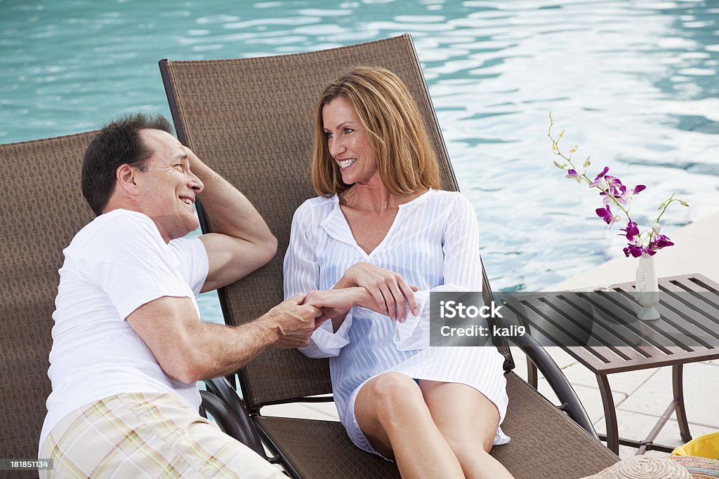 couple d'âge mûr tenant mains au bord de la piscine - Photo de Piscine libre de droits