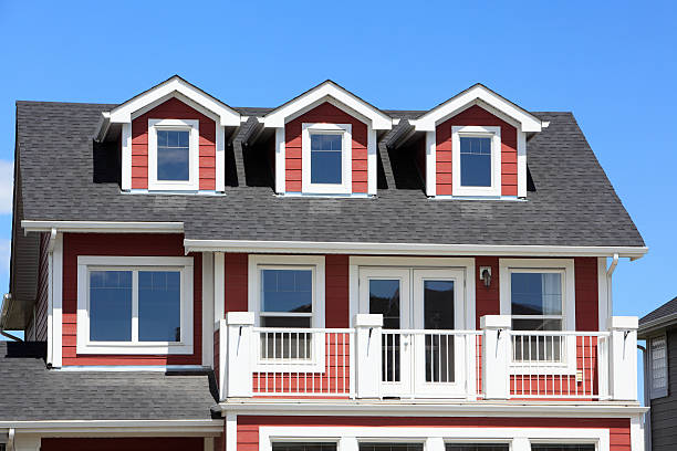 Exterior view of upper half of new modern red and white home.