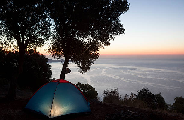 Camping tent in night by mediterranean sea