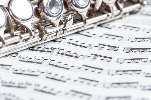 Close up of a silver flute on a sheet of music notes.Photos from the same series: