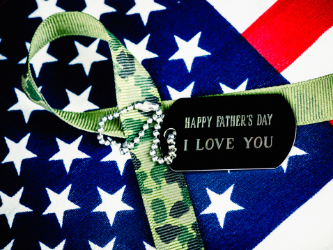 Military dog tag with a message for dad on top of an American flag