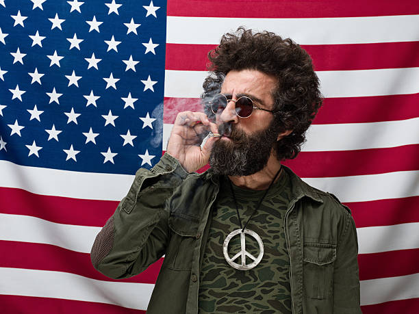 istock Pacifist in military uniform smoking before American flag 181854131