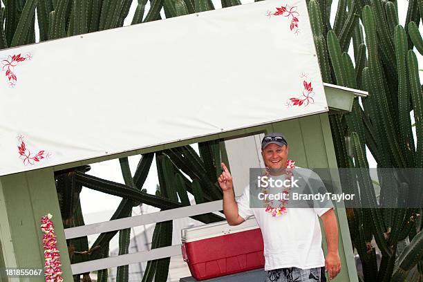 Photo libre de droit de Hawaiian Homme Souriant Pointant En Panneau Blanc banque d'images et plus d'images libres de droit de Adulte - Adulte, Big Island - Îles Hawaï, Collier de fleurs