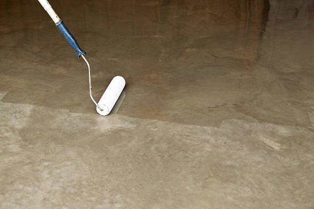 Clear Sealing New Concrete Floor with Paint Roller sealant photos stock pictures, royalty-free photos & images