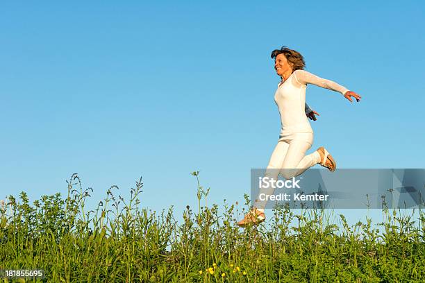 Happy Woman Running On Meadow Stock Photo - Download Image Now - Jumping, Women, Mature Adult