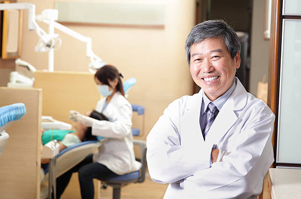 мужской стоматолог и его командой в офисе стоматолога - dentist asian ethnicity portrait male стоковые фото и изображения