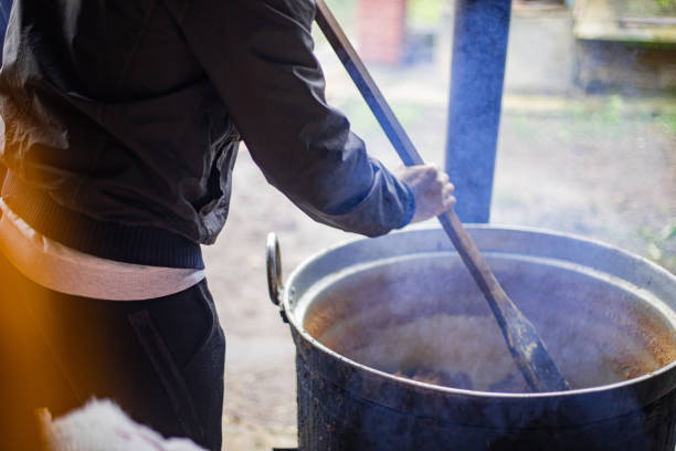 A cook cooks lard in a cauldron, traditional cuisine