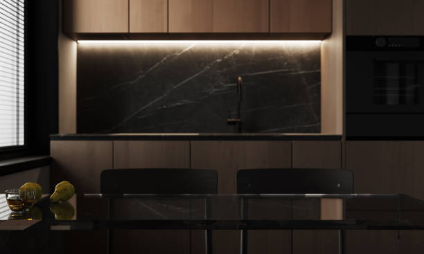 istock Mockup space on a luxury black glass tabletop with a blurred modern wooden kitchen 1818572879