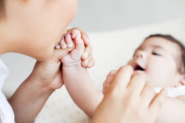 istock Mother kissing baby's hand 181857444