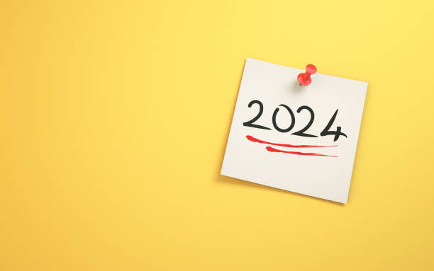 2024 New Year Text Written on Note Paper Sitting on Yellow Background