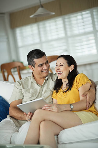 istock Couple With Digital Tablet Sitting On Sofa 181858625