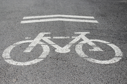 Sign for bicycle painted on the asphalt. Detail of road sign for cyclists in the city, sports and transport respecting the environment.