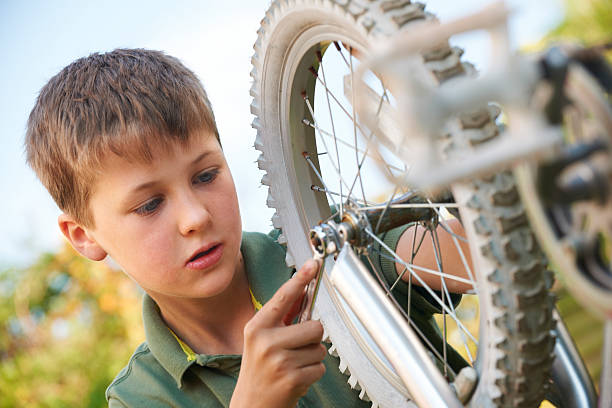 istock Boy Fixing Wheel Of Bike 181859053