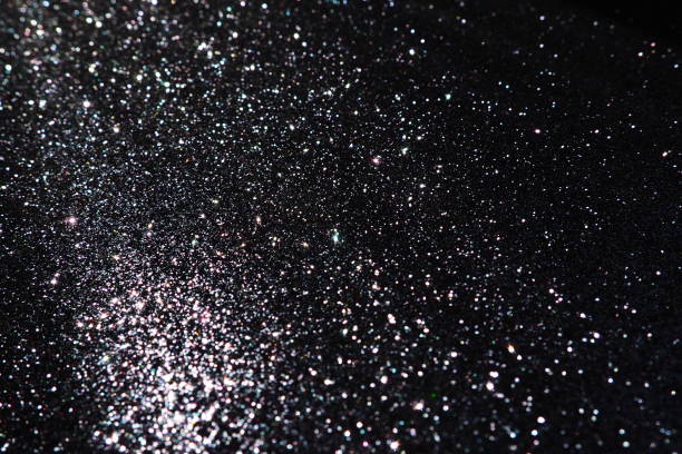 istock Oblique rays of light on a black surface. Bokeh, dust particles, reflection and magical glow. Festive shining background. New Year, Christmas, birthday. Plastic card design. Cosmic photons from space 1818592098