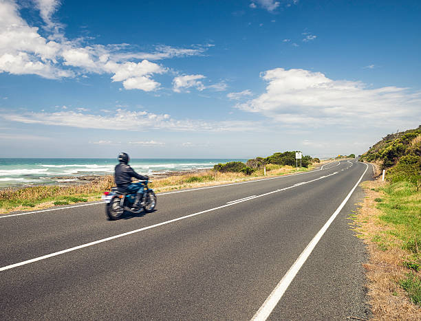 Motorbike Freedom on the Great Ocean Road in Australia A man riding a motorbike at speed along the Great Ocean Road in Victoria State, Australia. Also known as the Surfcoast Highway, the Great Ocean Road is one of Australia's best known routes. great ocean road photos stock pictures, royalty-free photos & images