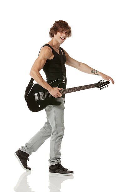 istock A young man holding guitar in white background 181859429
