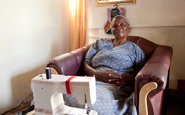 Elderly woman at home with her sewing machine. Gugulethu.