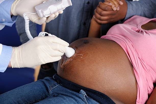afro-americana casal tendo uma fetais doppler/avaliação de pré-natal - midwife human pregnancy women multi ethnic group - fotografias e filmes do acervo