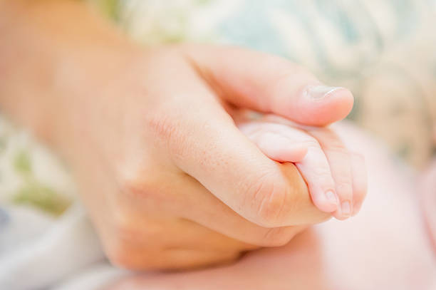 istock Mothers Hands and Babies Feet 181860163