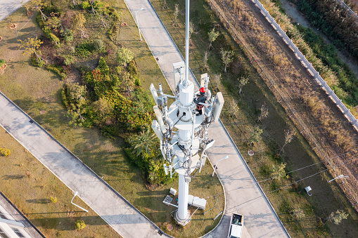 Aerial shot of communications workers repairing telecommunications towers