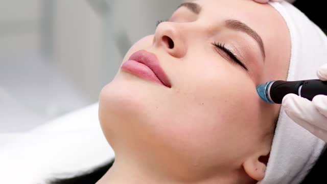 Modern cosmetology. Close-up of a modern hydrofacial device used to cleanse the face of a young woman.