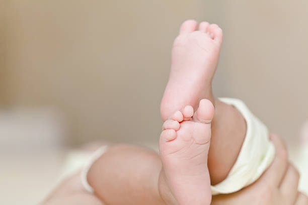 istock Mother's hands holding newborn's feet 181860843