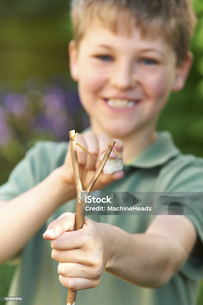 Garçon viser Lance-pierre dans le jardin - Photo de 6-7 ans libre de droits