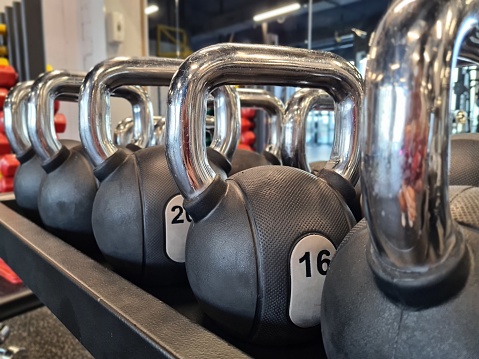 Row of weights in gym. Strength training with kettlebells in gym