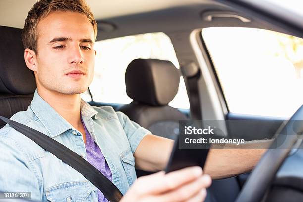 Foto de Jovem Homem Mensagens De Texto Enquanto Dirige Car e mais fotos de stock de 16-17 Anos - 16-17 Anos, 20 Anos, 25-30 Anos