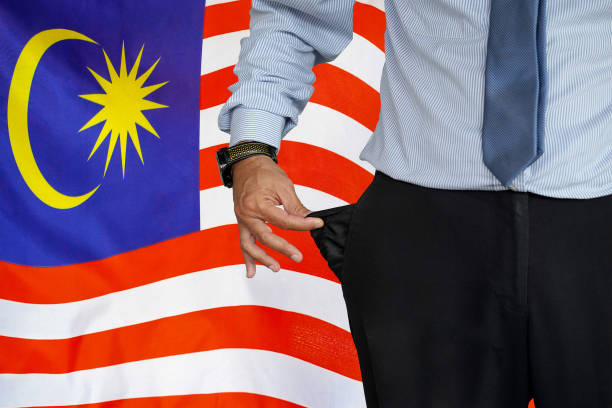 mann dreht seine hosentasche auf dem hintergrund der malaysischen flagge hoch - pants suit pocket men stock-fotos und bilder