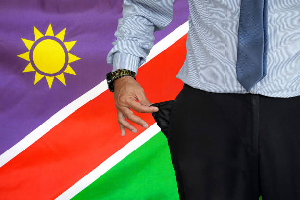 mann dreht seine hosentasche auf dem hintergrund der namibia-flagge hoch - pants suit pocket men stock-fotos und bilder