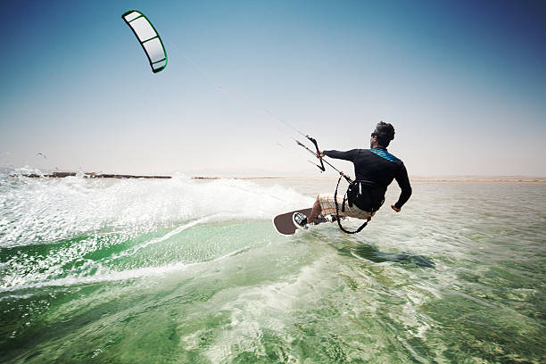 Man kiteboarding on choppy waves Kiteboarding kiteboarding stock pictures, royalty-free photos & images
