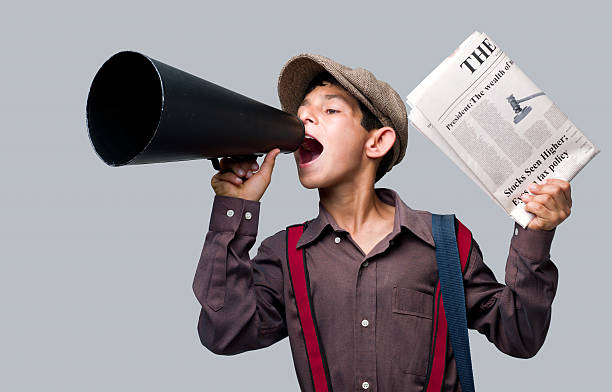 Newsboy holding newspaper and shouting to sell stock photo
