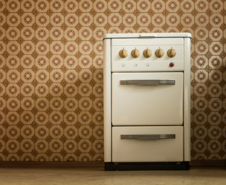 stove in old kitchen standing in front of pvc wallpaper