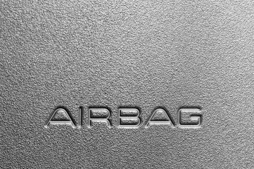 A close up image of a dashboard label saying Airbag. Copy space. Macro shot.