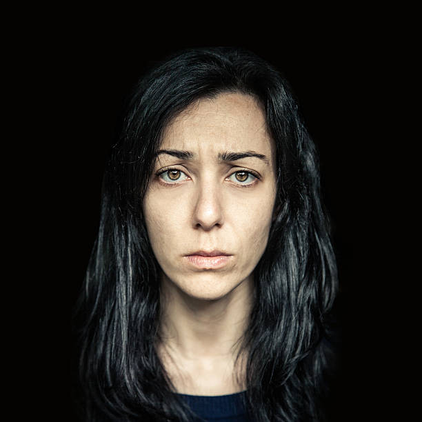 Serious woman portrait on black background.