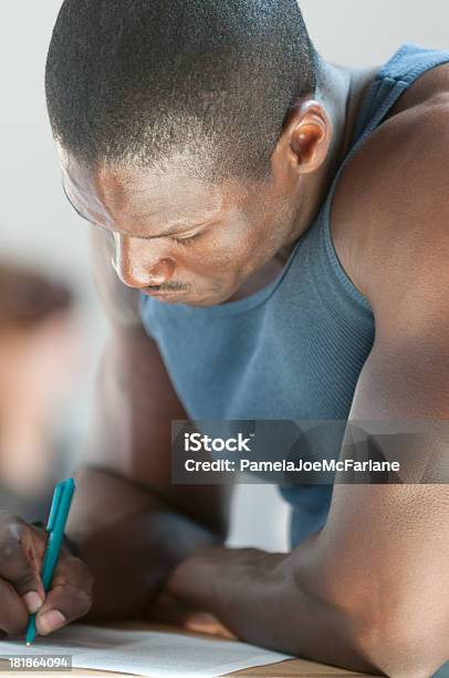 Foto de Atraente Jovem Afroamericano Homem Escrevendo e mais fotos de stock de Escrever - Escrever, Primeiro plano, Assinar